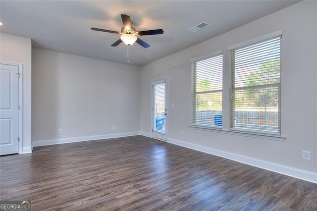 spare room with dark hardwood / wood-style flooring and ceiling fan