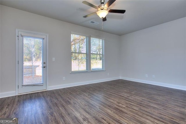 spare room featuring ceiling fan, a healthy amount of sunlight, and dark hardwood / wood-style flooring