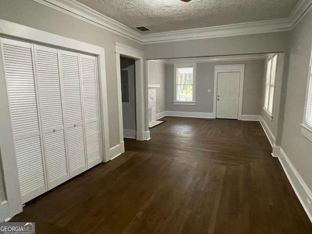 entrance foyer with crown molding, a textured ceiling, and dark hardwood / wood-style floors