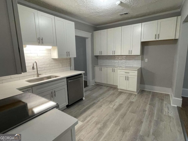 kitchen with dishwasher, white cabinetry, and sink