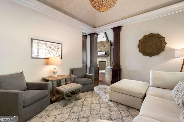 living room with ornate columns, wood-type flooring, a fireplace, and crown molding