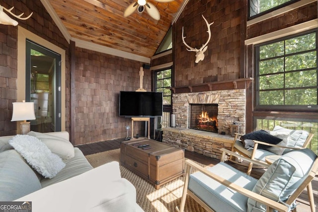 living room featuring ceiling fan, a fireplace, high vaulted ceiling, and wooden ceiling