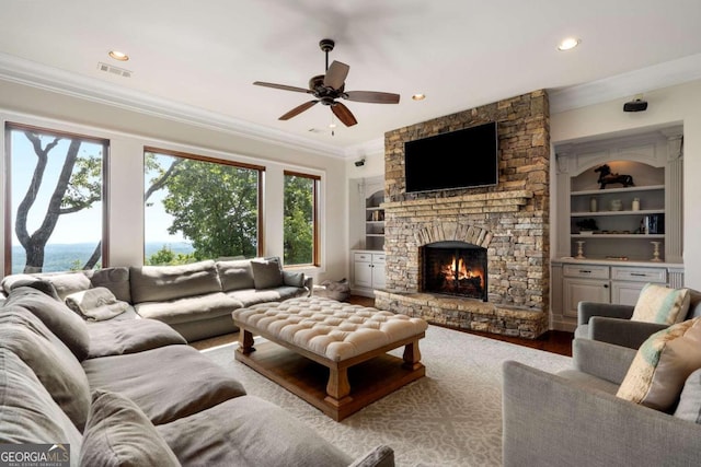 living room with ceiling fan, hardwood / wood-style flooring, a fireplace, and ornamental molding