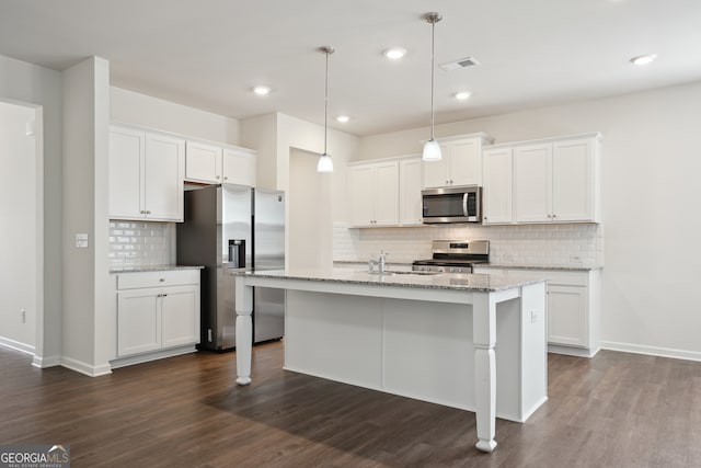 kitchen with decorative light fixtures, an island with sink, dark wood-type flooring, stainless steel appliances, and white cabinetry