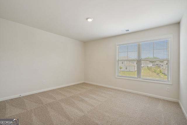 unfurnished room featuring light carpet