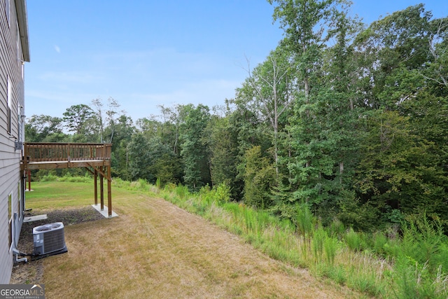 view of yard featuring a wooden deck and central air condition unit