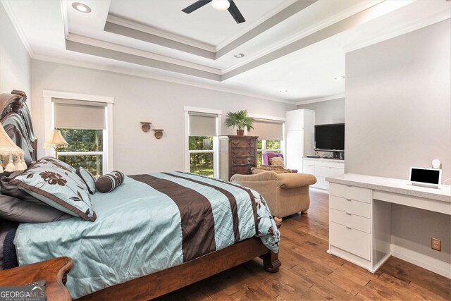 bedroom featuring ornamental molding, ceiling fan, a raised ceiling, and hardwood / wood-style floors