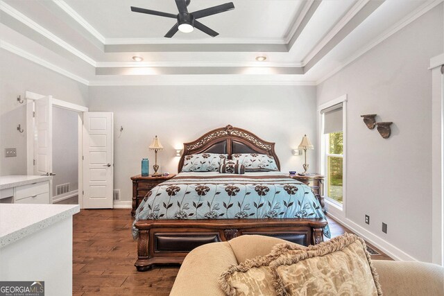 bedroom with ceiling fan, a raised ceiling, crown molding, and dark hardwood / wood-style floors