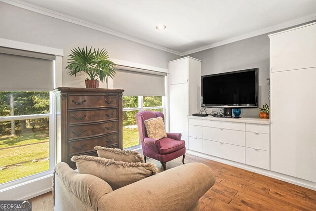 sitting room with crown molding and light hardwood / wood-style floors