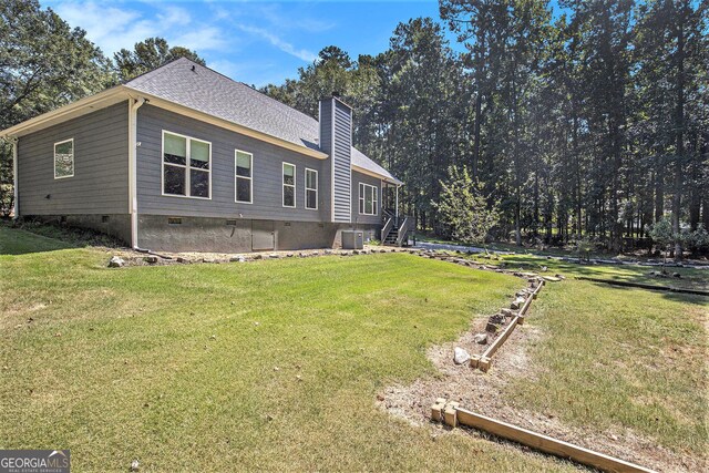 view of side of home with a yard and central air condition unit