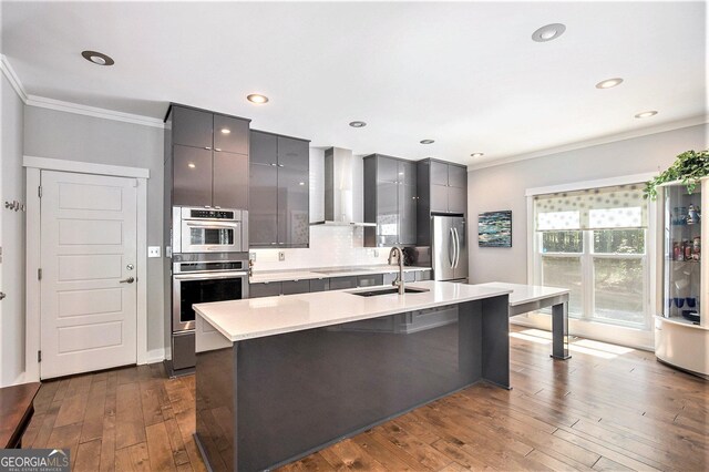 kitchen featuring sink, appliances with stainless steel finishes, gray cabinetry, and wall chimney exhaust hood