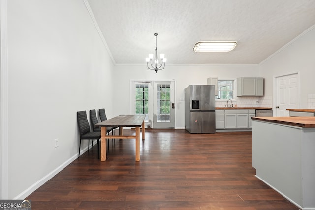 kitchen featuring pendant lighting, a textured ceiling, dark hardwood / wood-style floors, appliances with stainless steel finishes, and gray cabinetry