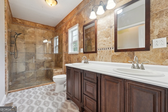 bathroom with tile patterned floors, toilet, tile walls, a shower with shower door, and vanity