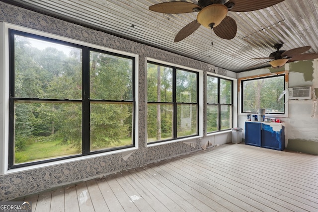 unfurnished sunroom with a healthy amount of sunlight, an AC wall unit, and ceiling fan