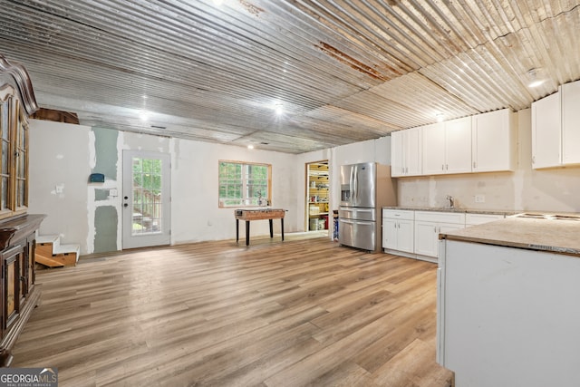 kitchen featuring white cabinets, light hardwood / wood-style flooring, light stone countertops, sink, and stainless steel refrigerator with ice dispenser