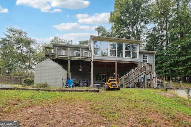 rear view of property featuring a yard, a shed, and a deck