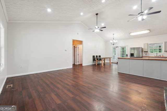 unfurnished living room with dark wood-type flooring, ceiling fan with notable chandelier, and a textured ceiling