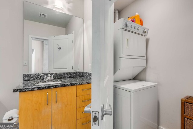 laundry area with sink and stacked washer / dryer