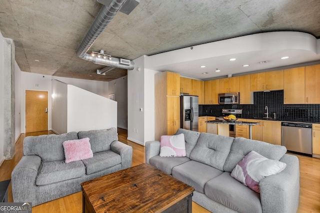 living room with light wood-type flooring and sink