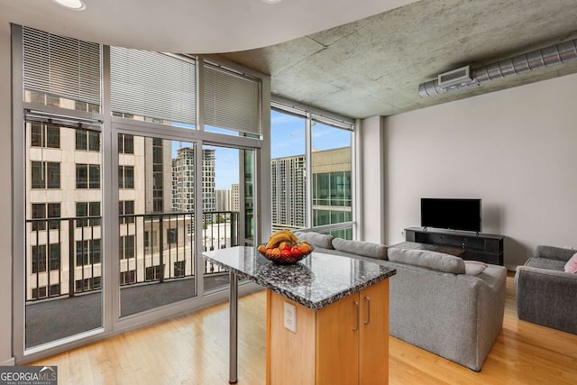 kitchen with floor to ceiling windows, a kitchen island, and light hardwood / wood-style flooring