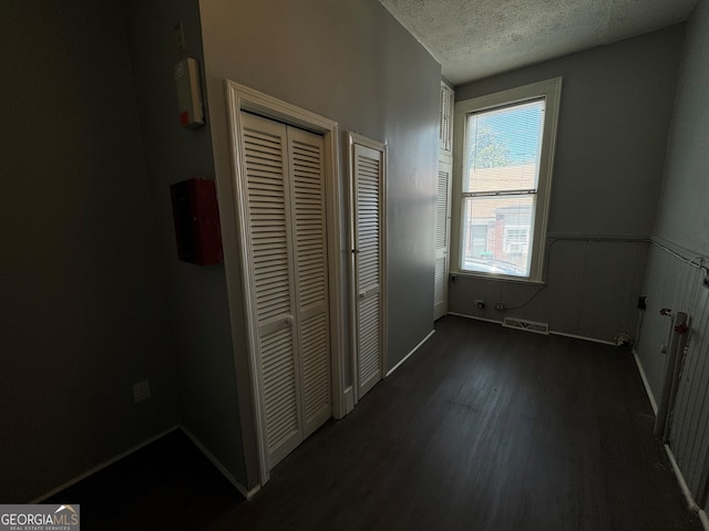 unfurnished bedroom featuring dark hardwood / wood-style floors and a textured ceiling