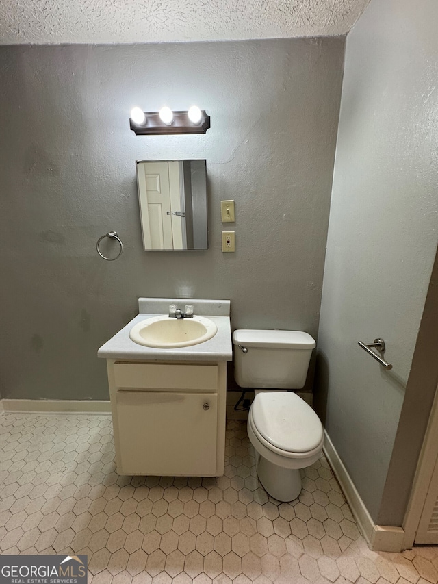 bathroom with vanity, a textured ceiling, and toilet