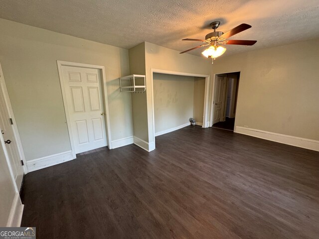 unfurnished bedroom featuring dark wood-type flooring, a textured ceiling, and ceiling fan