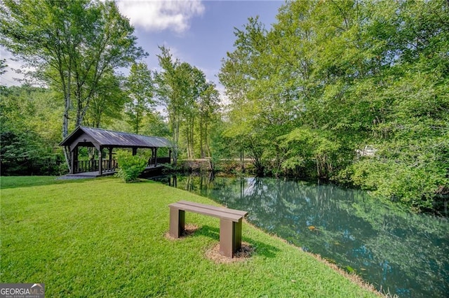 view of home's community with a gazebo, a water view, and a yard