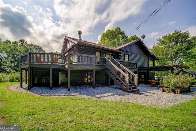 back of property with a wooden deck and a lawn