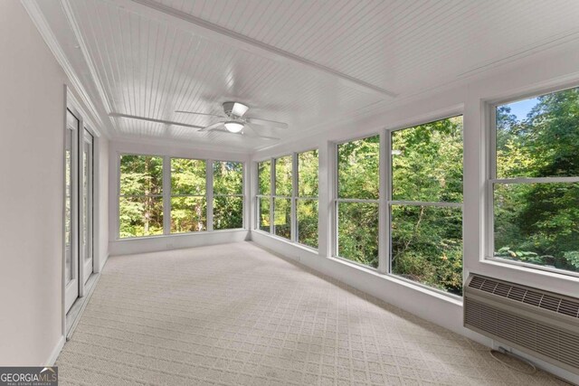 unfurnished sunroom featuring ceiling fan and a healthy amount of sunlight