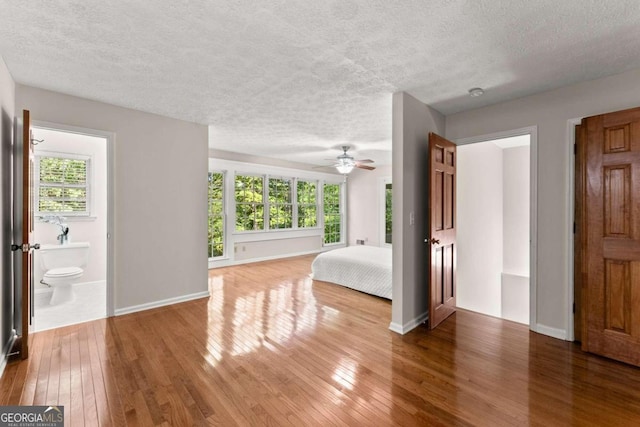 5775 Lakeshore Dr, Buford, GA 30518 - unfurnished bedroom featuring hardwood / wood-style flooring, a textured ceiling, multiple windows, and baseboards