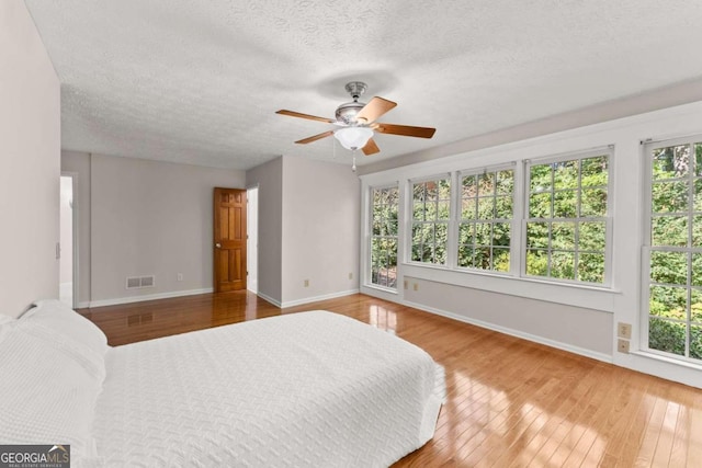5775 Lakeshore Dr, Buford, GA 30518 - bedroom with wood-type flooring, multiple windows, and a textured ceiling
