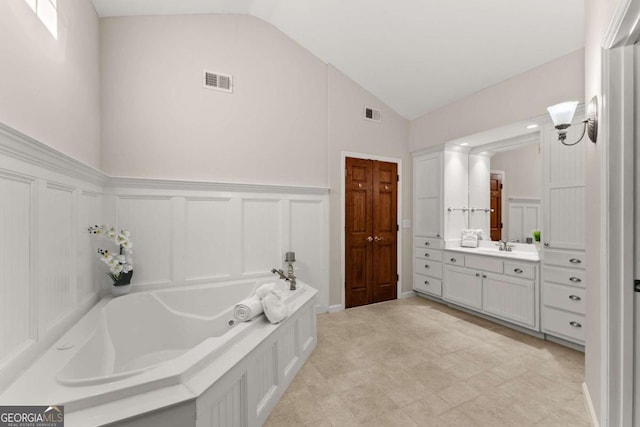 5775 Lakeshore Dr, Buford, GA 30518 - full bath with a jetted tub, vanity, a decorative wall, a wainscoted wall, and high vaulted ceiling