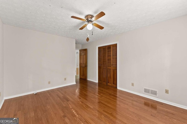 5775 Lakeshore Dr, Buford, GA 30518 - empty room featuring wood finished floors, a ceiling fan, baseboards, and a textured ceiling
