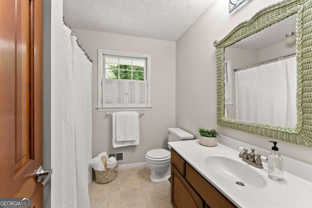 bathroom featuring tile patterned flooring, toilet, a textured ceiling, and vanity