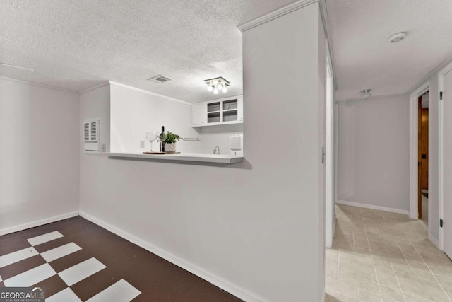 corridor with a textured ceiling and light tile patterned floors