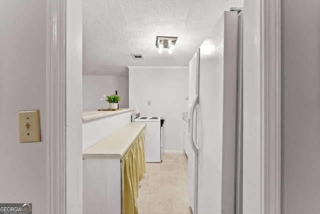 corridor featuring a textured ceiling and light tile patterned floors