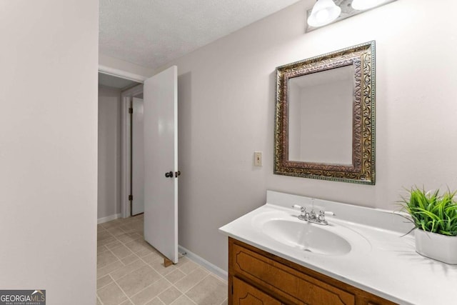 bathroom with tile patterned flooring, a textured ceiling, and vanity