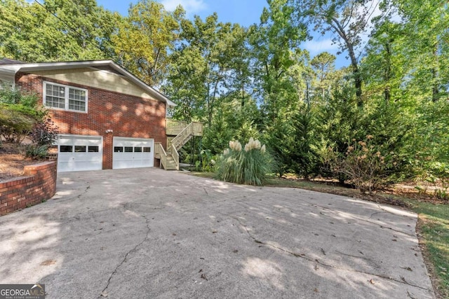 5775 Lakeshore Dr, Buford, GA 30518 - view of home's exterior with stairway, asphalt driveway, brick siding, and an attached garage