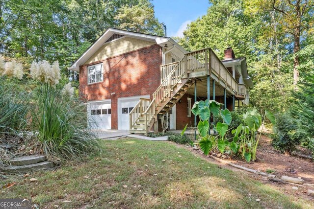 view of front facade with a wooden deck, a garage, and a front yard