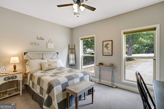 bedroom with ceiling fan, light carpet, and multiple windows