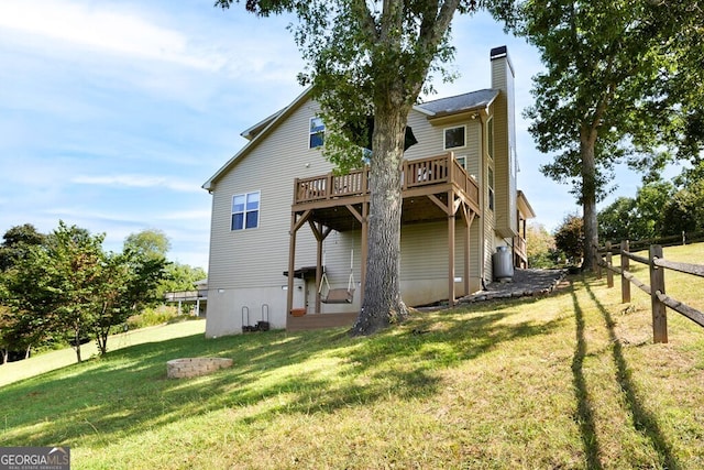 back of house with a deck and a lawn