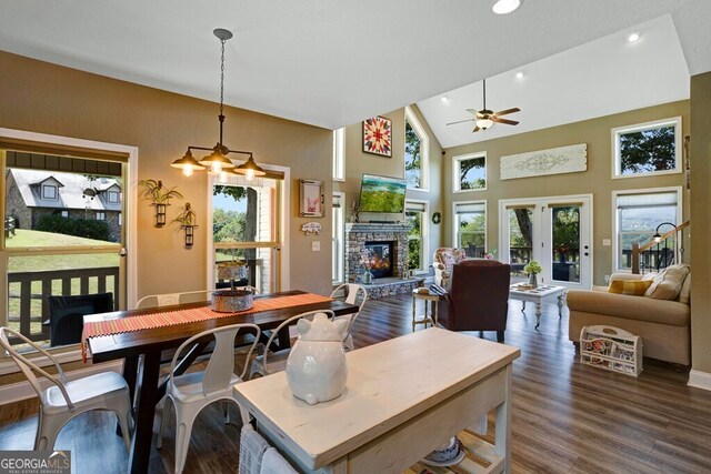 dining area featuring plenty of natural light, ceiling fan, and a stone fireplace