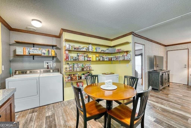 dining area with washer and dryer, light hardwood / wood-style flooring, ornamental molding, and a textured ceiling