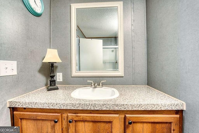 bathroom featuring a textured ceiling and vanity