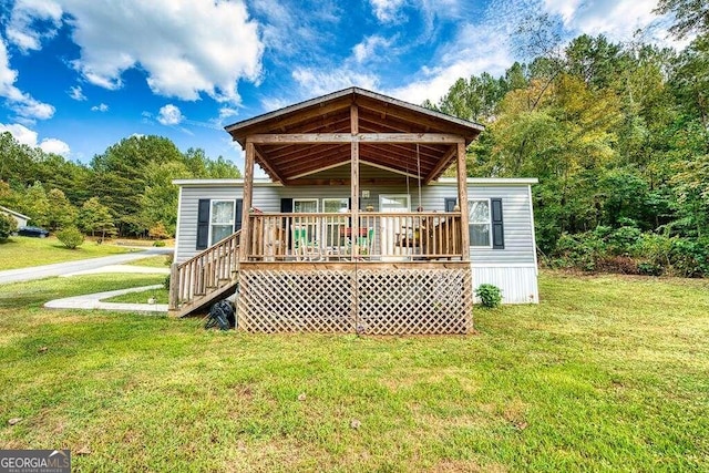 rear view of property with a lawn and a deck