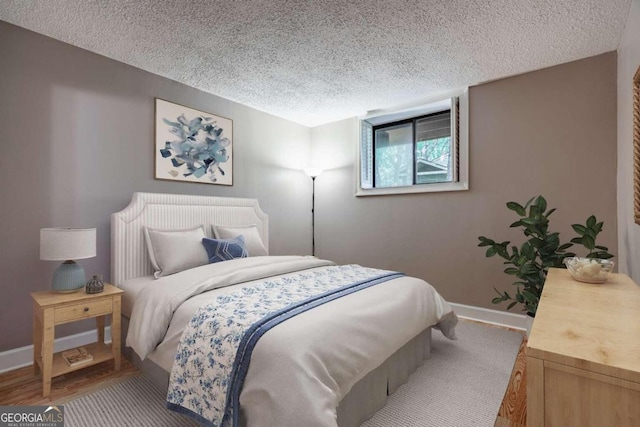 bedroom with wood-type flooring and a textured ceiling