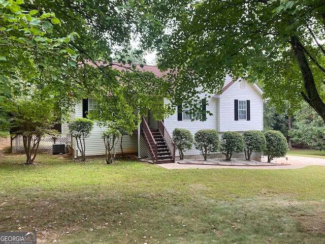 view of front of property with central AC unit and a front lawn