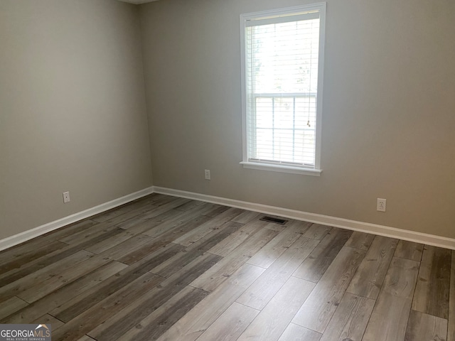 spare room featuring plenty of natural light and light hardwood / wood-style flooring