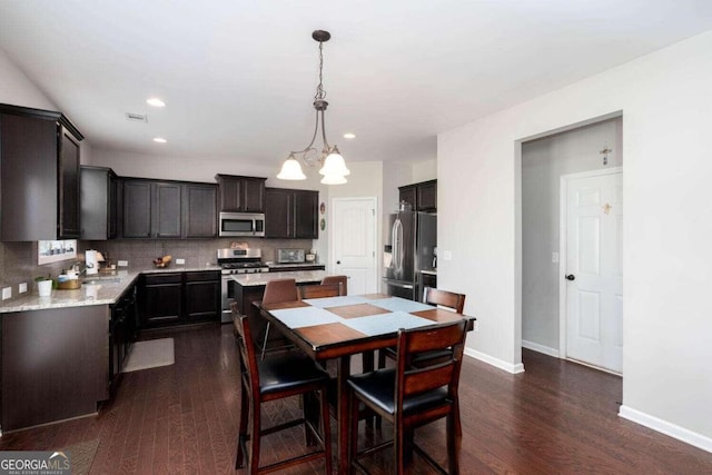 dining area featuring a notable chandelier and dark hardwood / wood-style floors